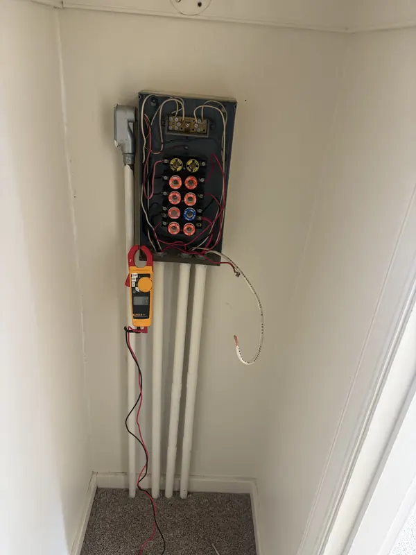 Old fuse panel located inside a closet, without the required working clearance